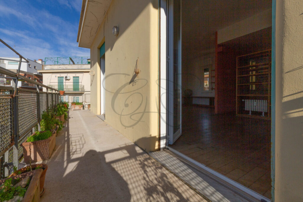 Accesso dal soggiorno alla balconata abitabile dell'appartamento venduto a Monteverde Vecchio, con vista esterna in una giornata di sole.