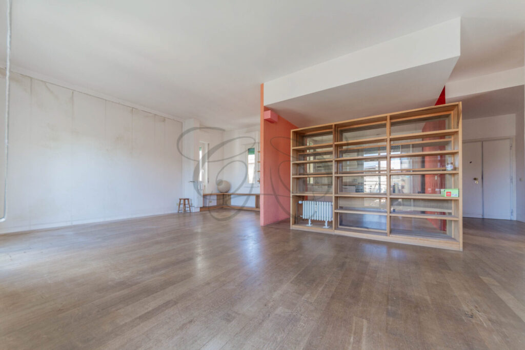 Altra vista del salone dell'appartamento venduto a Monteverde Vecchio, con grande libreria in legno a tutta parete e pavimento in parquet.