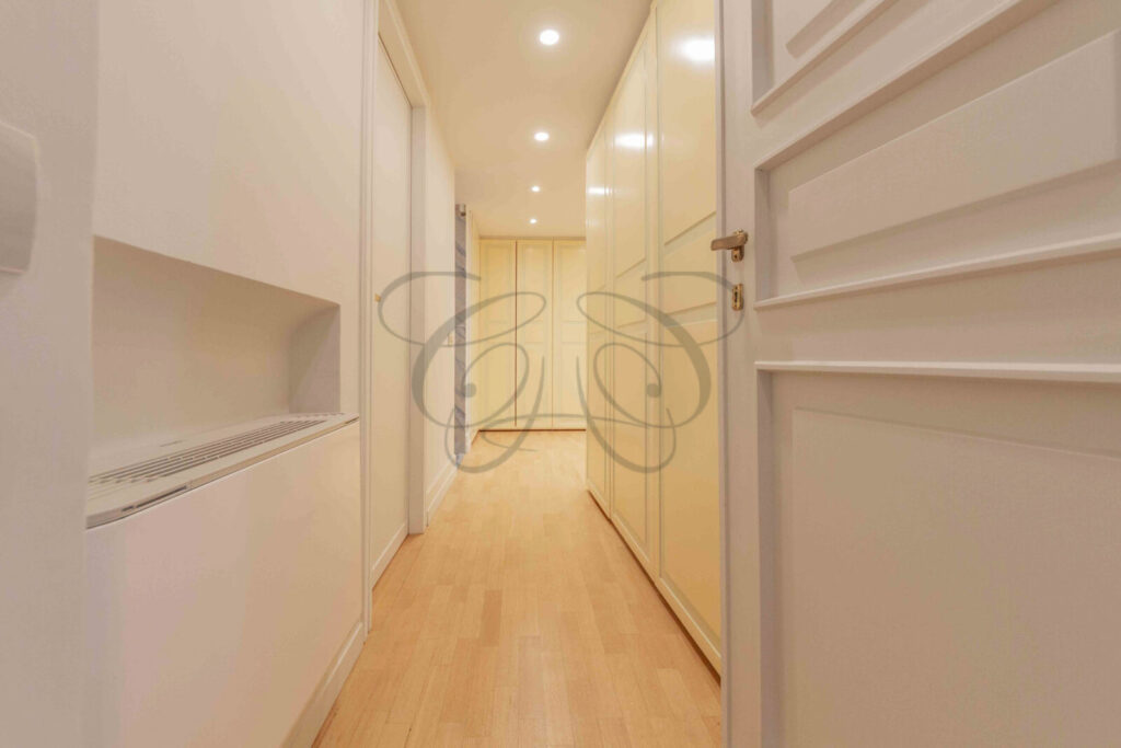 Particolare di un corridoio d'ingresso con pareti decorate con motivi ornamentali in un attico di prestigio a Roma.