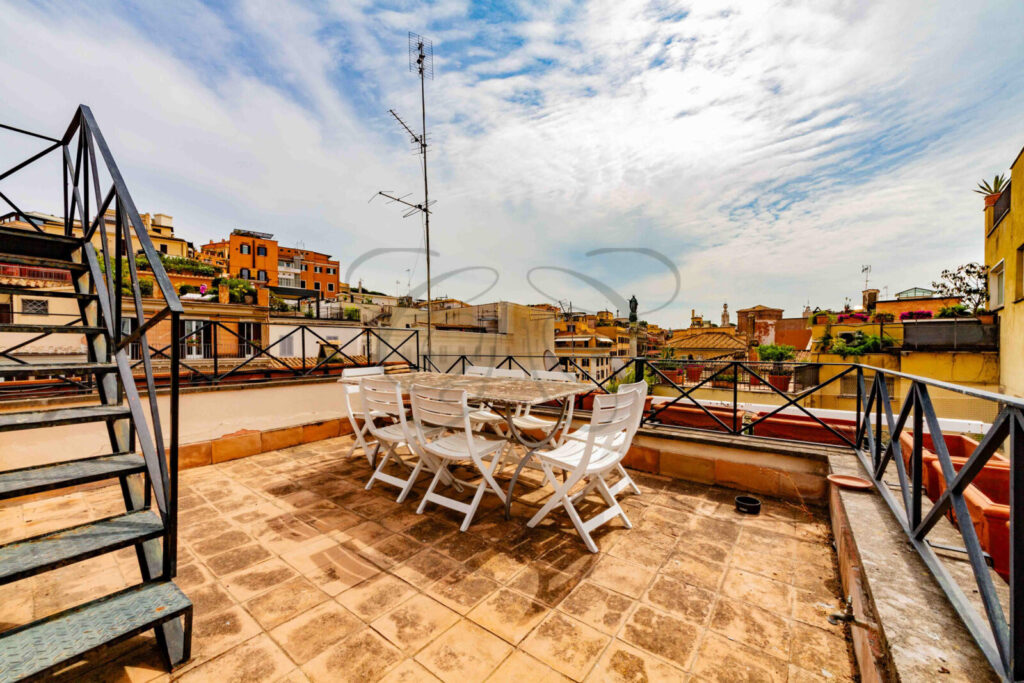 Terrazza panoramica di un attico di lusso in affitto a Roma, con vista sui tetti del centro storico.