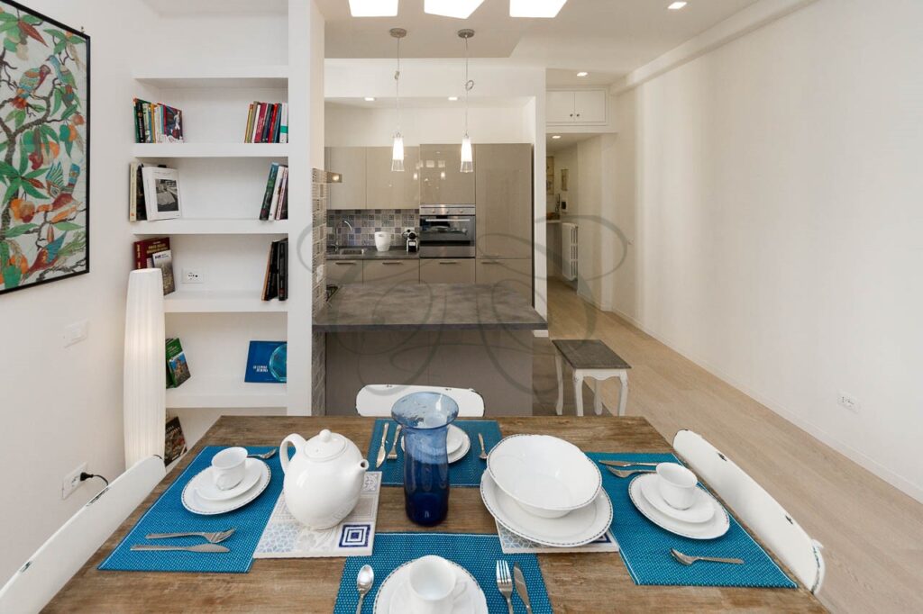 L'ampia zona giorno con cucina a vista, cuore di questo moderno appartamento recentemente affittato a Ponte Milvio.