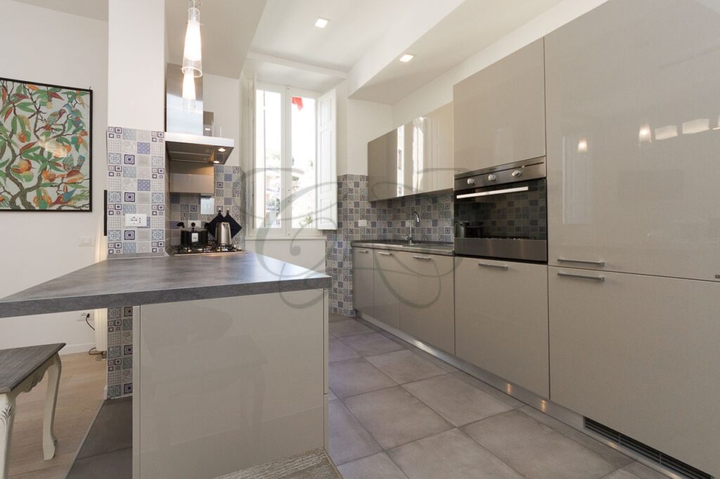 Soggiorno con cucina a vista di design in appartamento ristrutturato e affittato da Class & Country Homes a Roma, Ponte Milvio.