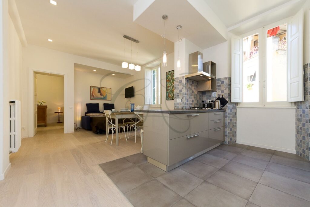 Soggiorno con cucina a vista di design in appartamento ristrutturato e affittato da Class & Country Homes a Roma, Ponte Milvio.