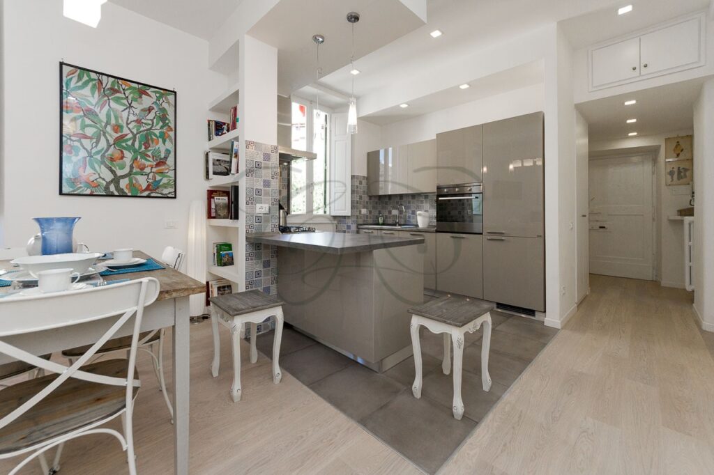 Soggiorno con cucina a vista di design in appartamento ristrutturato e affittato da Class & Country Homes a Roma, Ponte Milvio.