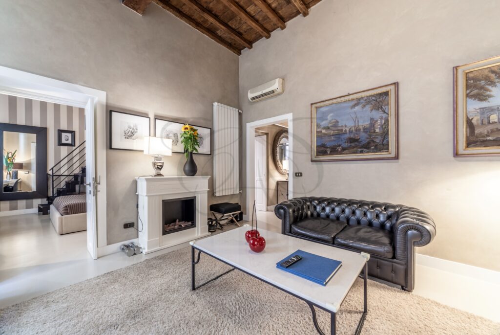 Salone con camino, divano e un'area adibita a studio con scrivania.