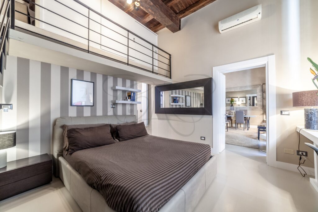 Vista dal soppalco verso il basso, che mostra la struttura e l'arredamento della camera sottostante.