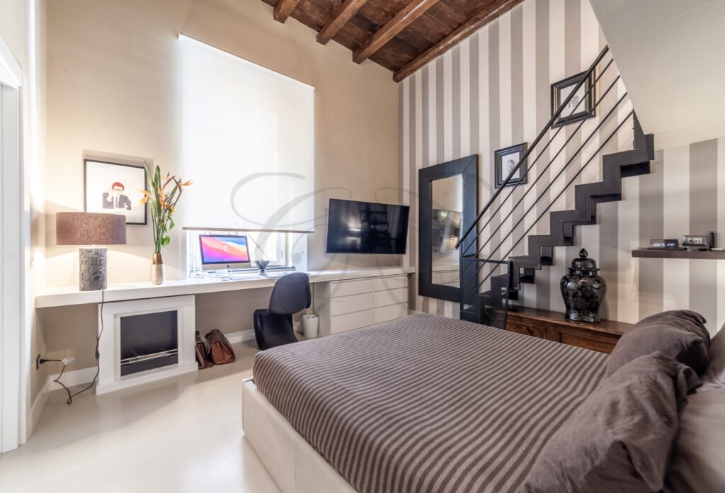 Scrivania e sedia posizionate in un angolo della casa, con un'illuminazione ben studiata.