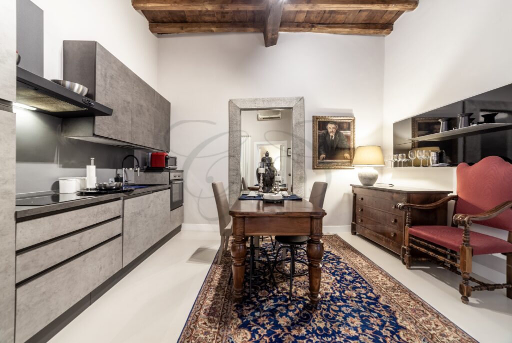 Dettaglio di un tavolo da pranzo in legno e sedie in una cucina con pavimenti in parquet.