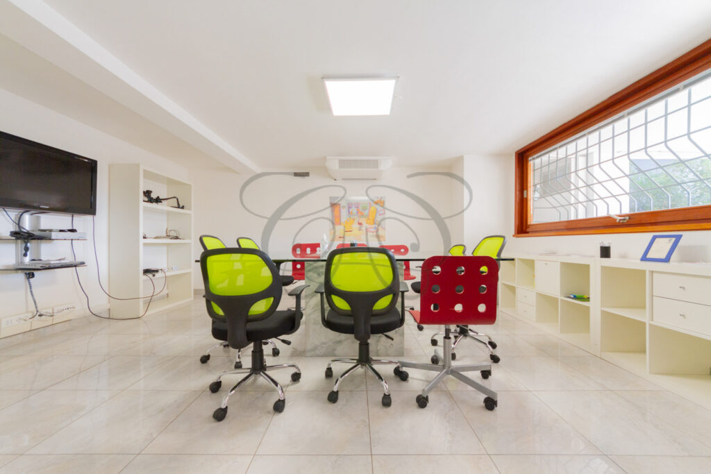 Sala riunioni moderna con sedie colorate, ufficio in affitto EUR - Class & Country Homes.