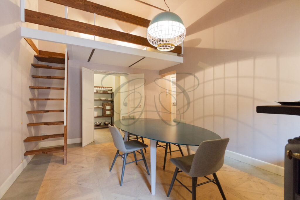 Sala da pranzo con soppalco in attico arredato e affittato da Class & Country Homes a Roma.