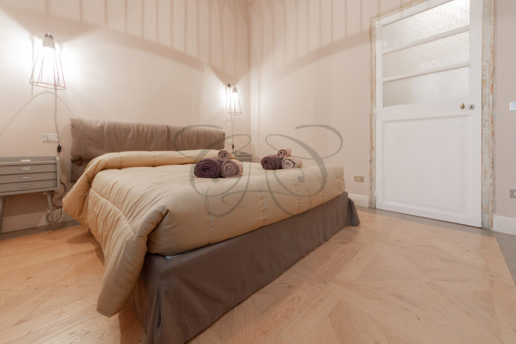 Camera da letto in stile industrial-chic in attico affittato da Class & Country Homes a Roma.
