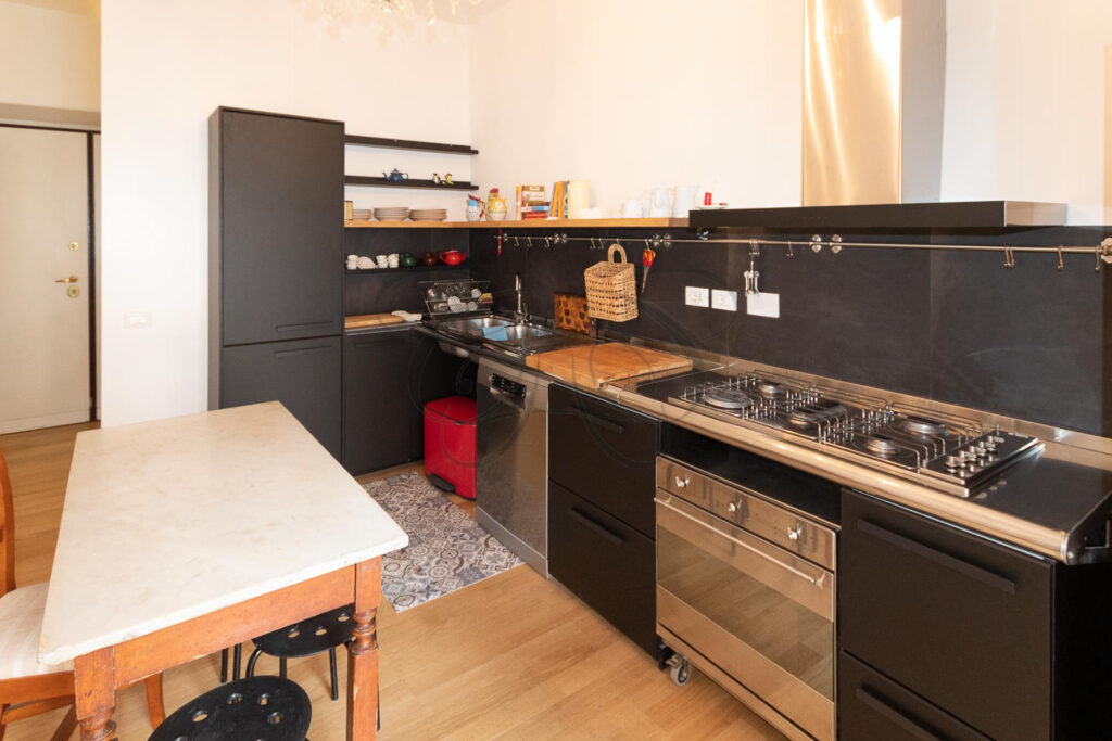 Vista ravvicinata del piano cottura e del forno in una cucina moderna con un design pulito ed essenziale.
