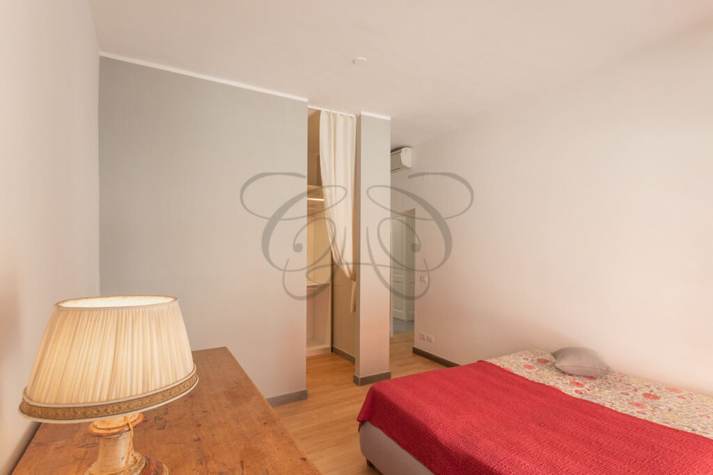 La camera da letto con le ante dell'armadio aperte che mostrano lo spazio interno.