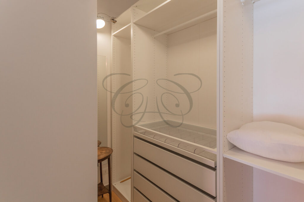 Un'altra prospettiva della cabina armadio con scaffali e cassetti.
