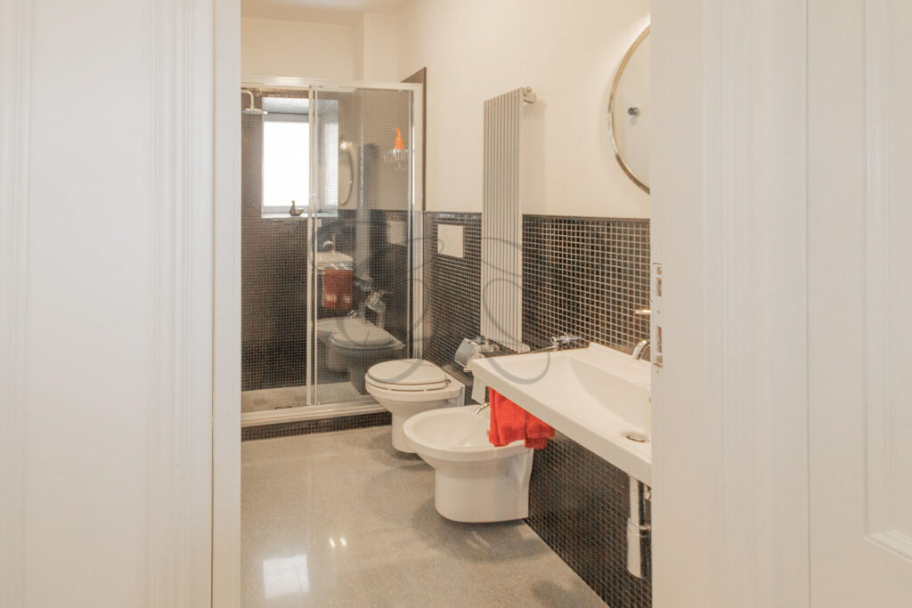 Il bagno moderno con un lavabo doppio, uno specchio e un water.