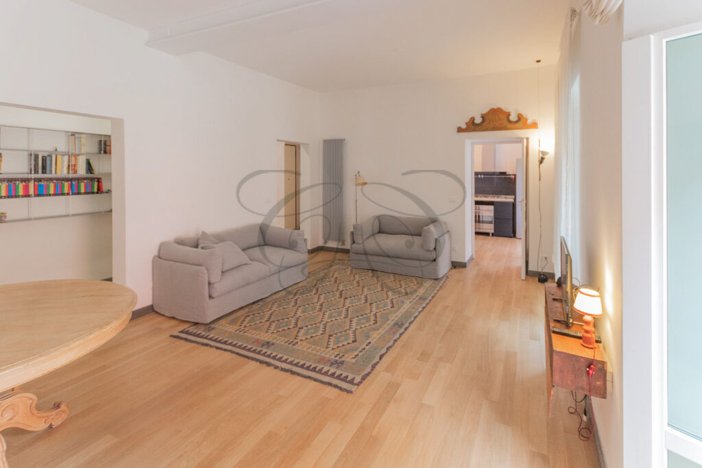 Una prospettiva che mostra il divano moderno e l'arredamento che crea un piacevole contrasto con lo stile antiquario.