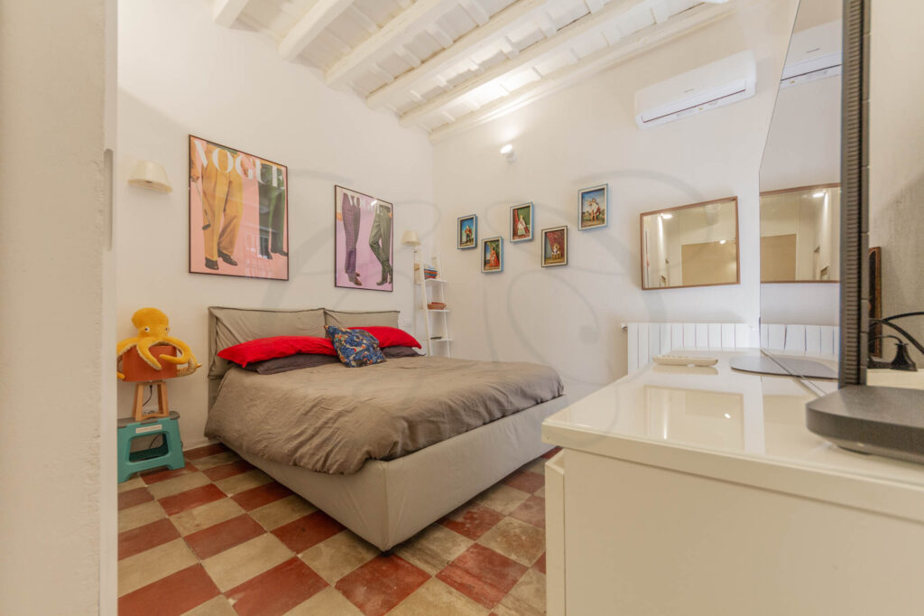 Camera da letto di un appartamento di design venduto da Class & Country Homes a Roma.