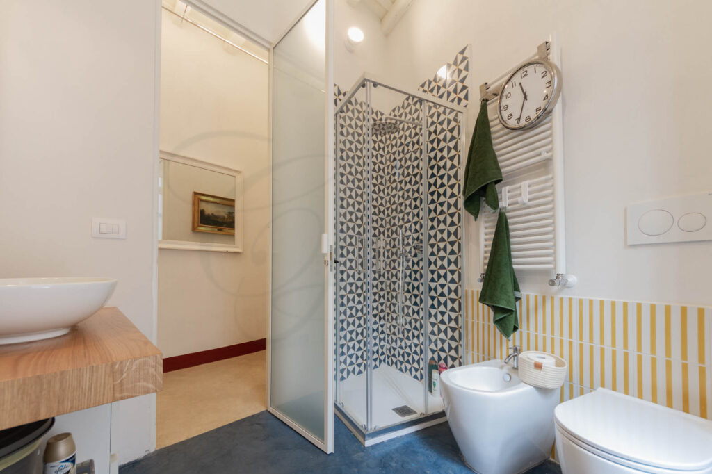 Secondo bagno con doccia e accesso al balcone, in un appartamento venduto da Class & Country Homes a Roma.