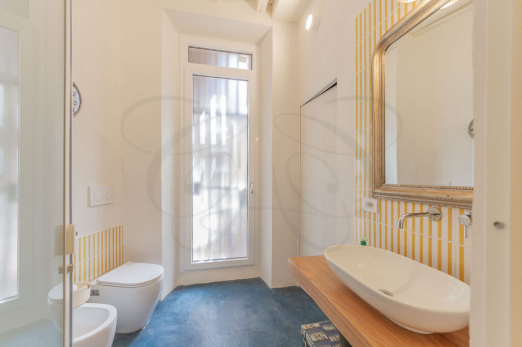 Dettaglio del bagno in microcemento, in un appartamento di design venduto da Class & Country Homes.