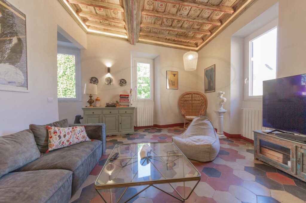 Salotto accogliente e raffinato in Appartamento Trastevere: arredamento elegante, pavimenti in cementine esagonali e luminosi affacci su via Garibaldi e l'arco della Lungara