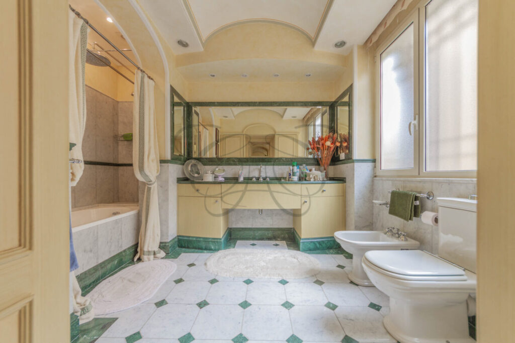 Sala da bagno padronale con vasca in un attico di lusso venduto da Class & Country Homes a Roma.