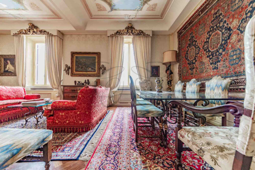 Salone con camino e terrazzo in attico di lusso affittato da Class & Country Homes a Roma.