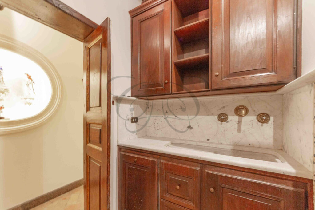 Una cucina compatta con superfici in marmo, elettrodomestici moderni e mobili in legno.
