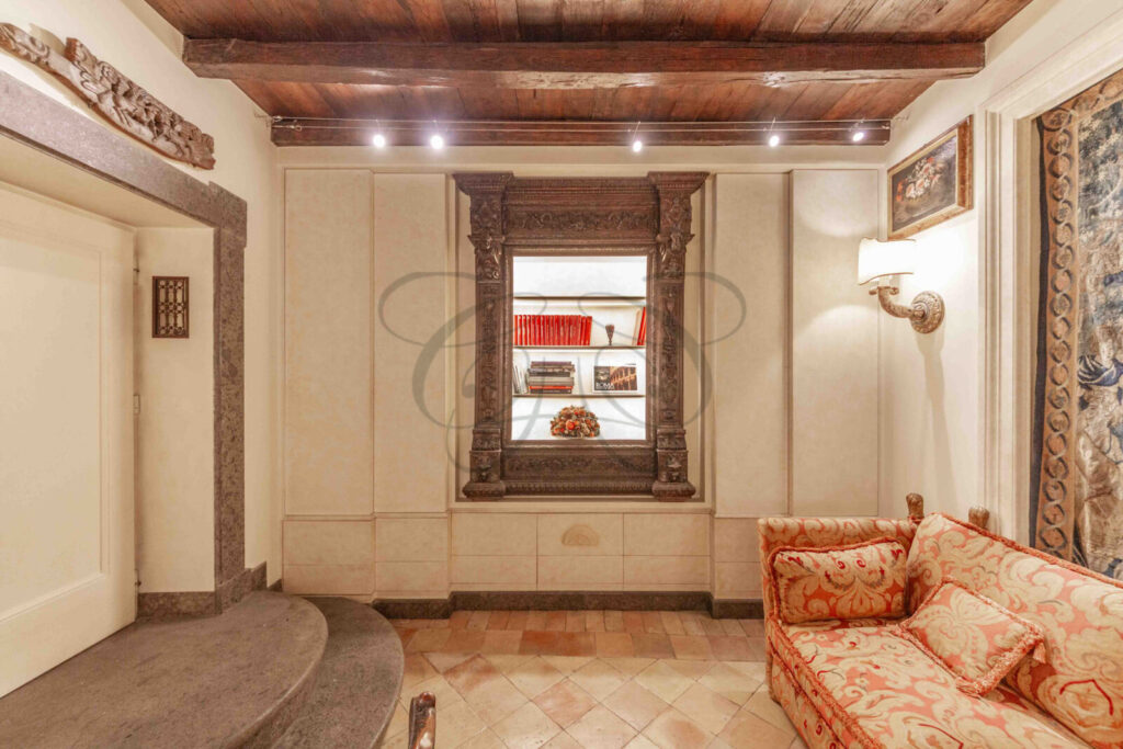 Un dettaglio di un living con arredi eleganti e un'antica edicola toscana, a firma Class & Country Homes.