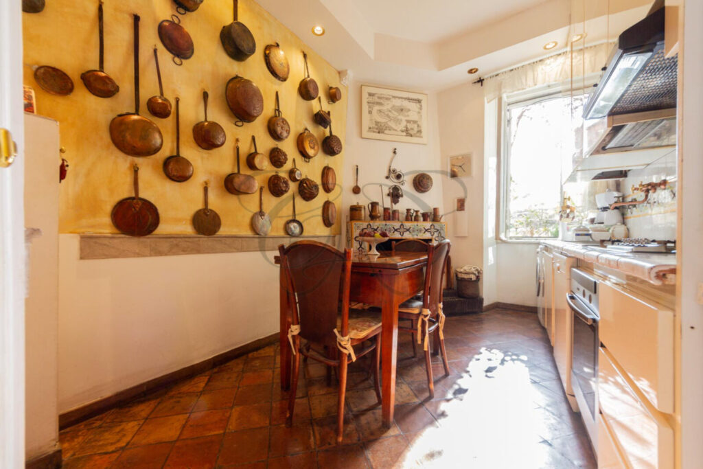 Cucina abitabile con camino in un appartamento di lusso venduto da Class & Country Homes a Roma, Rione Monti.