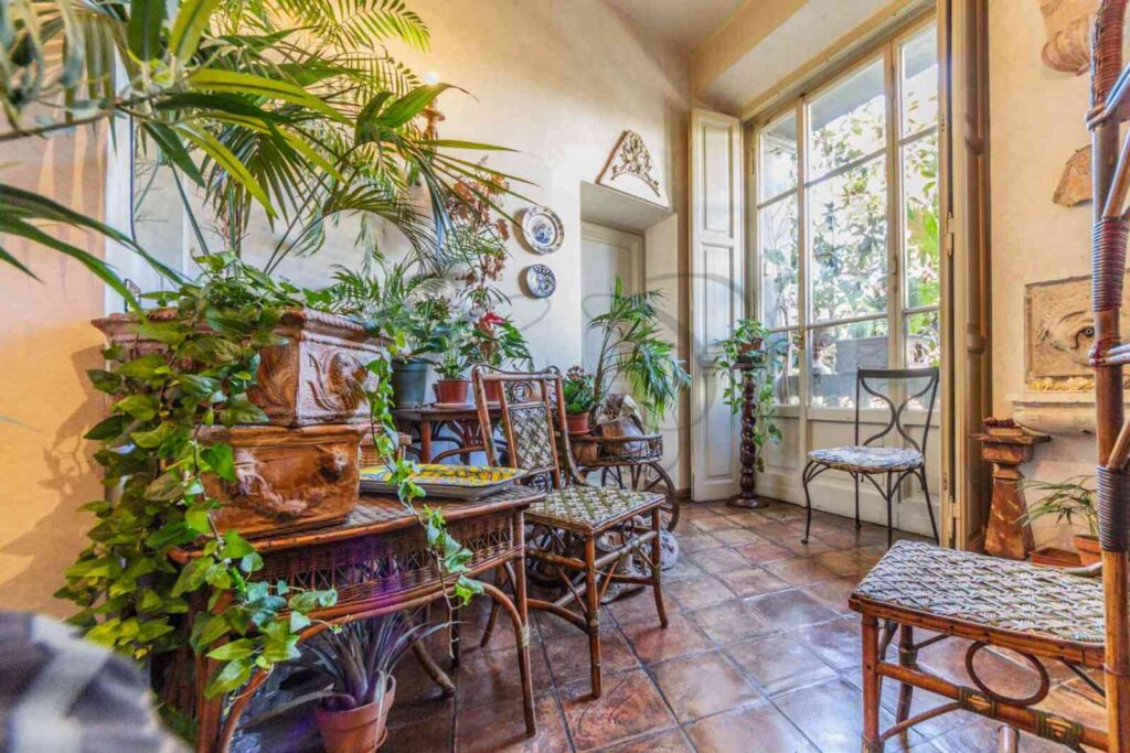 Giardino d'inverno con grande vetrata in appartamento di lusso venduto da Class & Country Homes a Roma, Rione Monti.