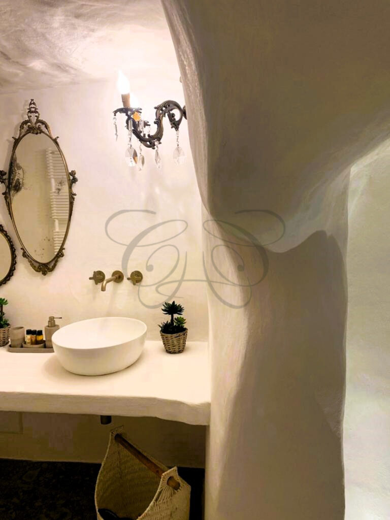 The unique bathroom carved into a grotto in the luxuriously renovated dammuso for sale in Noto, Sicily.