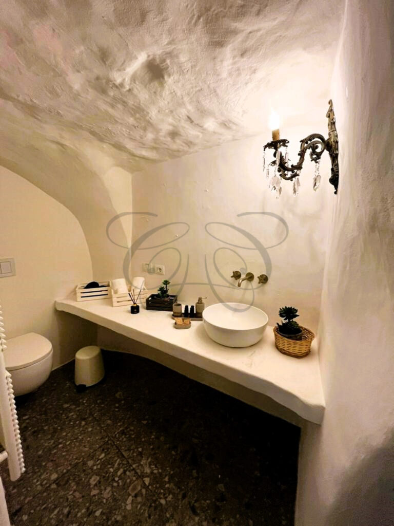 The contrast of white walls and modern design in a luxuriously renovated dammuso for sale.