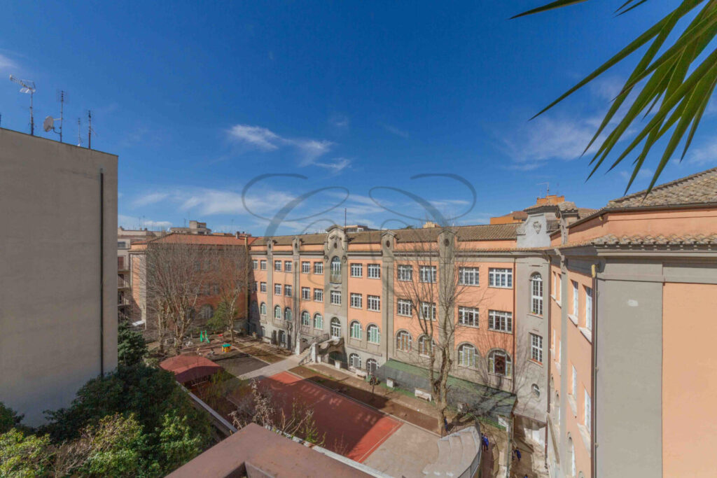 Vista esterna di un palazzo moderno a Roma, con facciata beige e finestre regolari.
