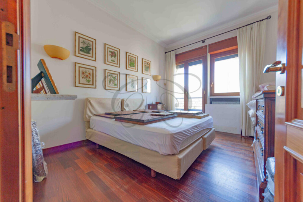 Interno della camera da letto padronale, con due quadri appesi sopra il letto.