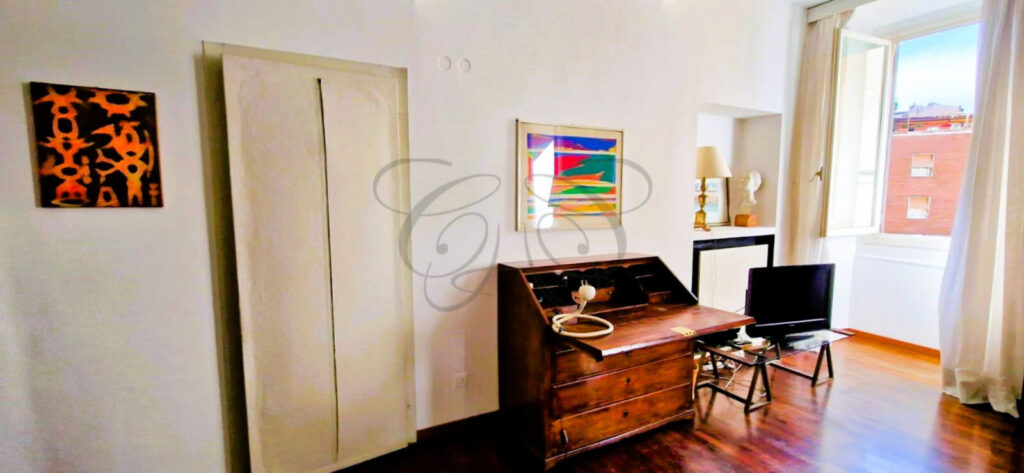 Ampia camera da letto con camino funzionante in un appartamento di lusso affittato da Class & Country Homes a Roma.