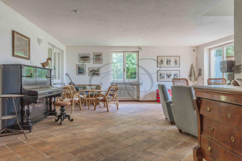 Salone principale con grande camino in pietra in una villa da ristrutturare in vendita a Manziana.