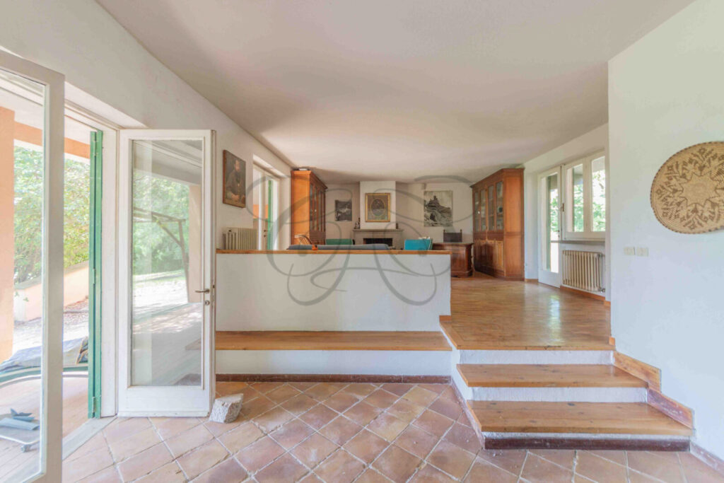 Salone principale con grande camino in pietra in una villa da ristrutturare in vendita a Manziana.