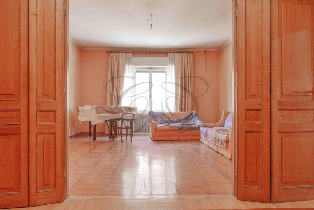 Salone con parete scorrevole per creare una sala da pranzo, appartamento venduto da Class & Country Homes a Roma.