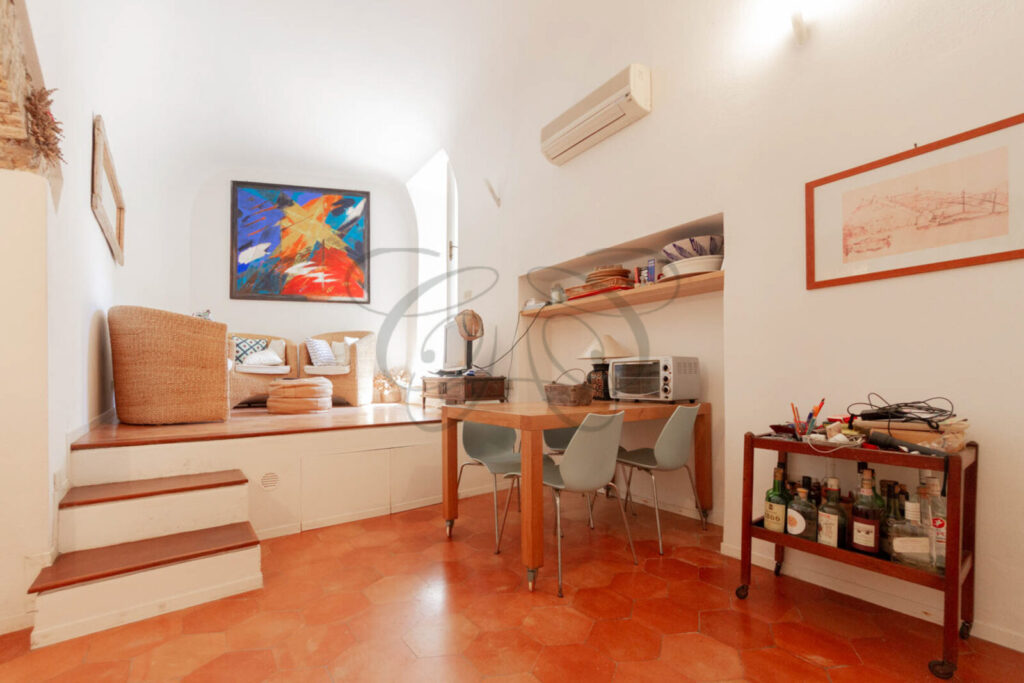 Soggiorno con arco in mattoni e pavimento in cotto della torre in vendita a Porto Ercole.