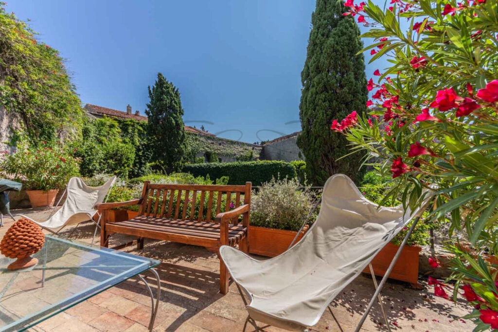 Giardino privato con patio e cipressi, immobile in vendita nella Rocca di Porto Ercole.