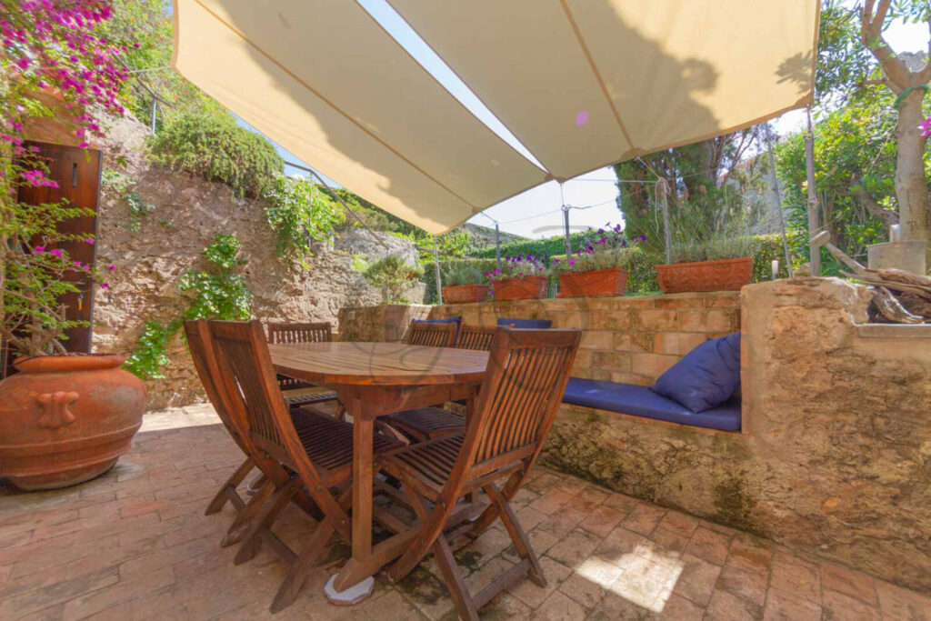 Giardino privato con patio e cipressi, immobile in vendita nella Rocca di Porto Ercole.