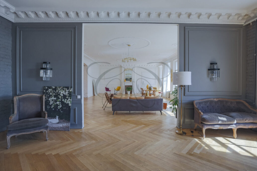 Salone luminoso con boiserie e parquet, in un appartamento di prestigio venduto da Class & Country Homes a Roma.