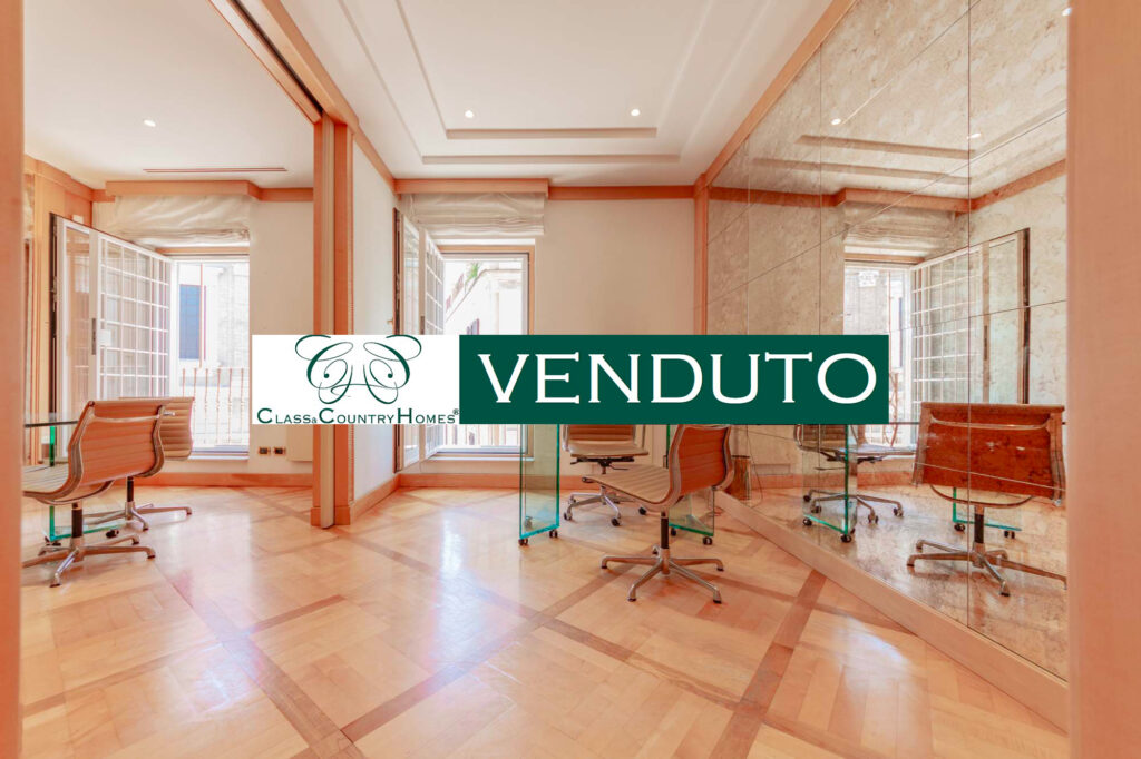 Interno elegante con boiserie, parquet e scrivania in vetro, appartamento in vendita Piazza di Spagna, Roma.
