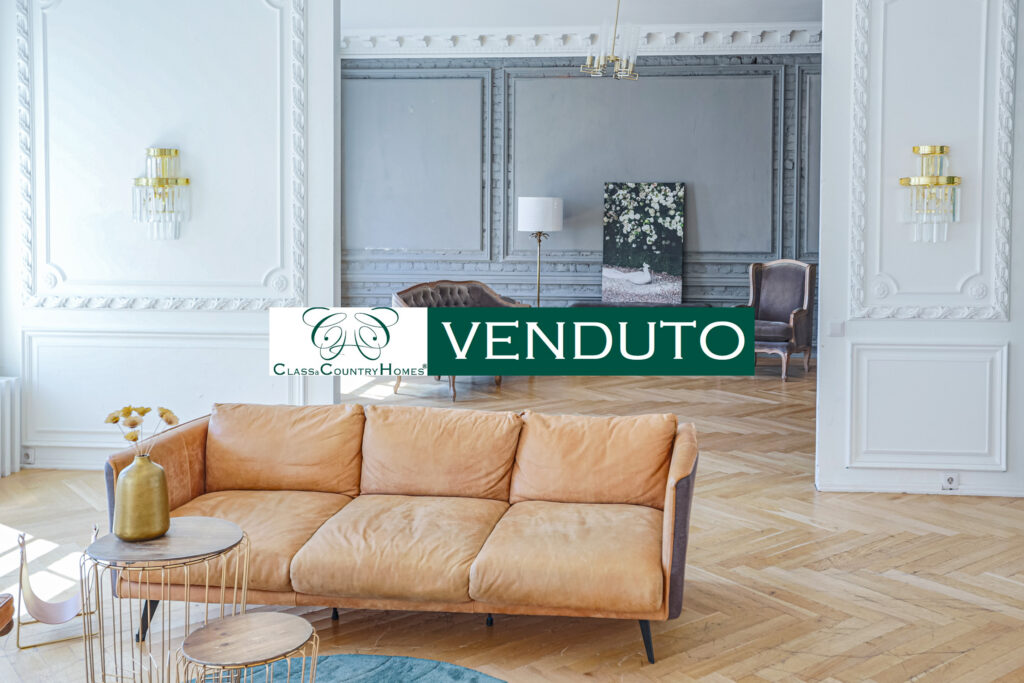 Salone con boiserie e arredi di design in un appartamento venduto da Class & Country Homes a Roma, Ghetto.
