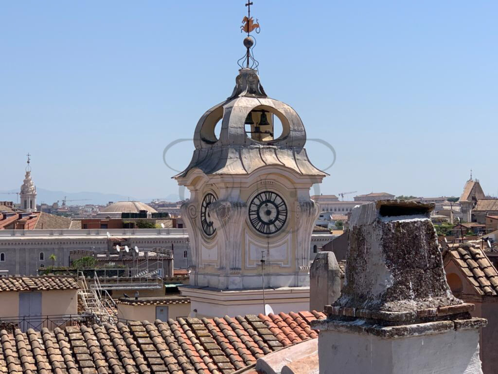 View over Rome's rooftops with a clock tower from the terrace of the penthouse for rent, historic center.