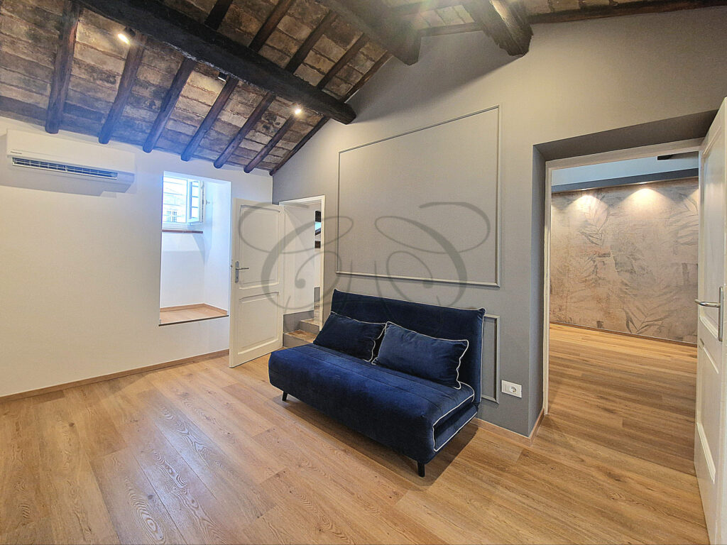 The living room and open kitchen area of a designer attic apartment for rent near Piazza Navona, Rome.