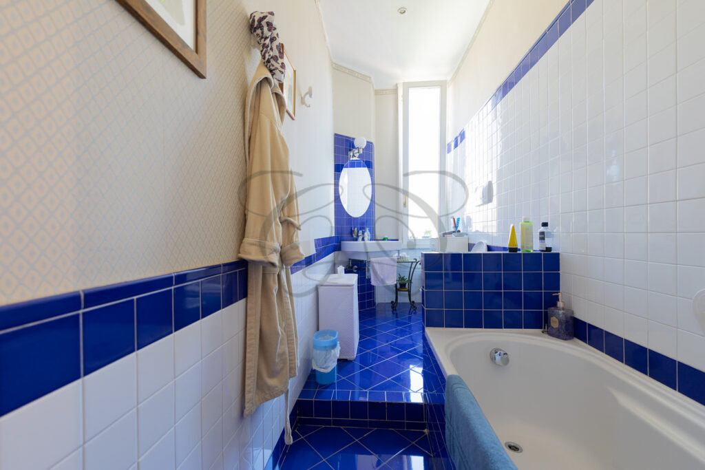 Bagno con vasca e piastrelle blu, appartamento in vendita come nuda proprietà a Roma Flaminio.