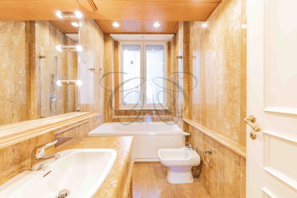 Sala da bagno con vasca, rivestimenti in marmo in un appartamento di lusso a Roma Parioli.