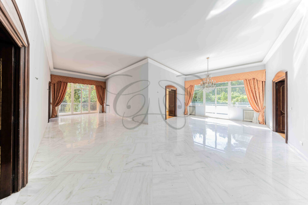 Atrio d'ingresso di un appartamento di lusso a Roma Parioli, con pavimento in marmo e vista sulle doppie porte dei saloni.
