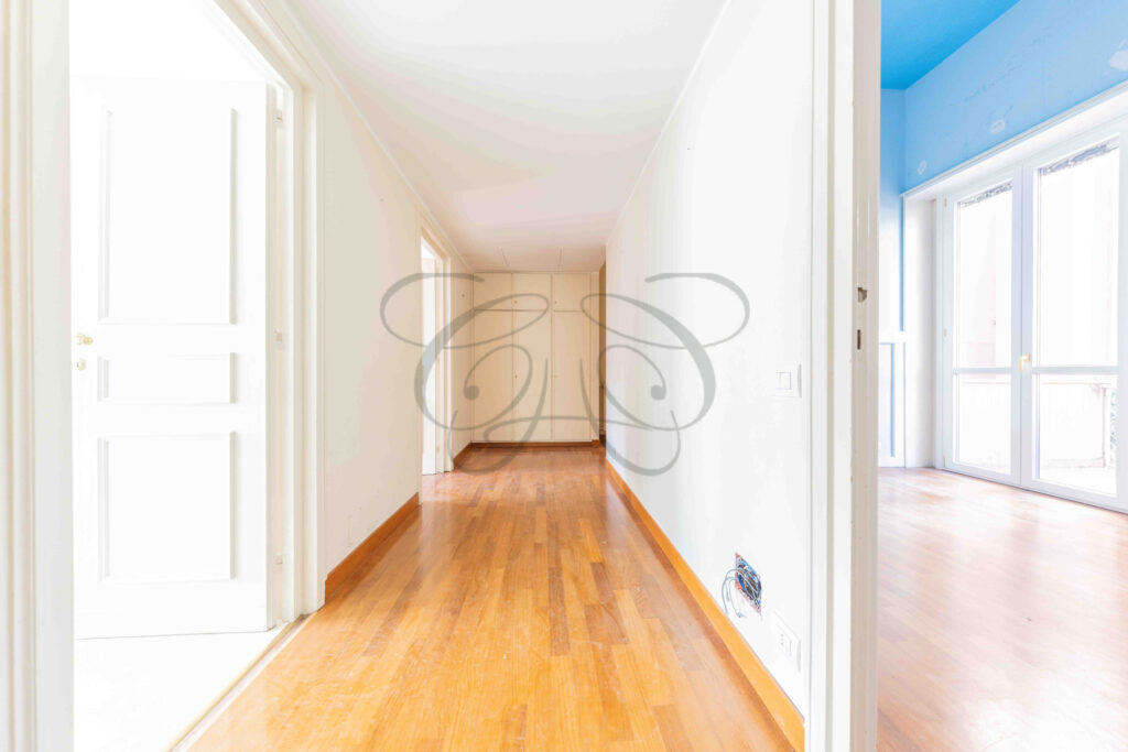 Corridoio dell'ala privata con pavimento in parquet che conduce alle camere da letto in un appartamento di lusso a Roma Parioli.